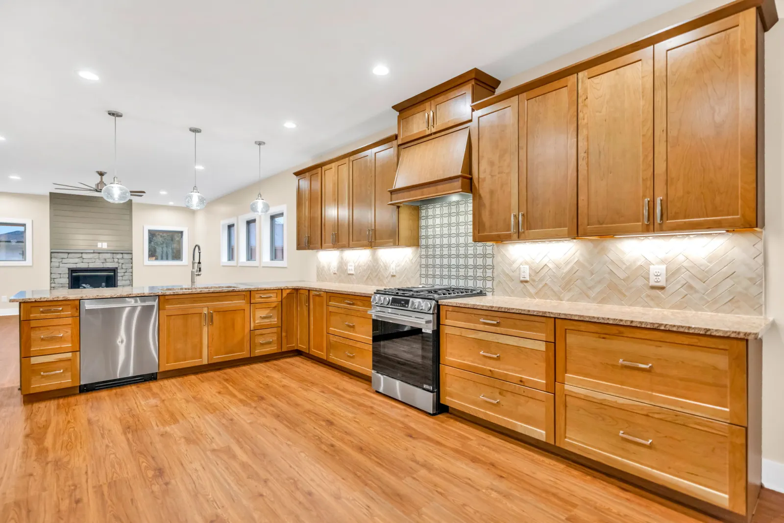 Open kitchen with cherry cabinetry and granite counters running toward the living area
